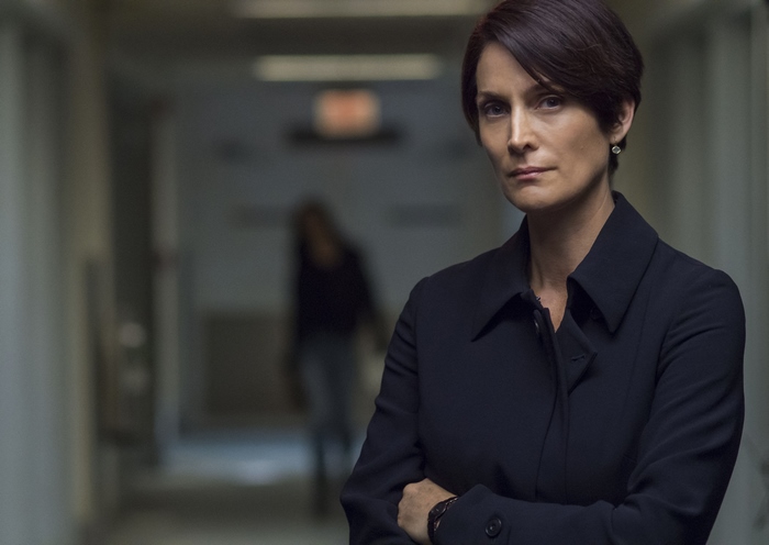 Carrie-Anne Moss in a dark hallway