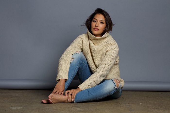 Janina Gavankar sitting on the floor