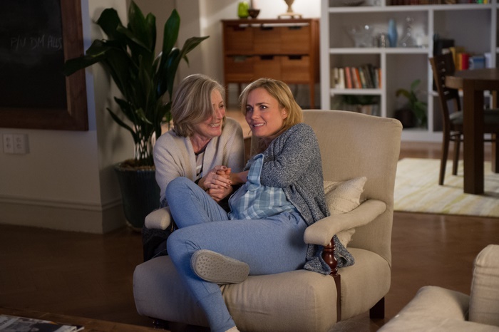 Radha Mitchell sitting in a chair