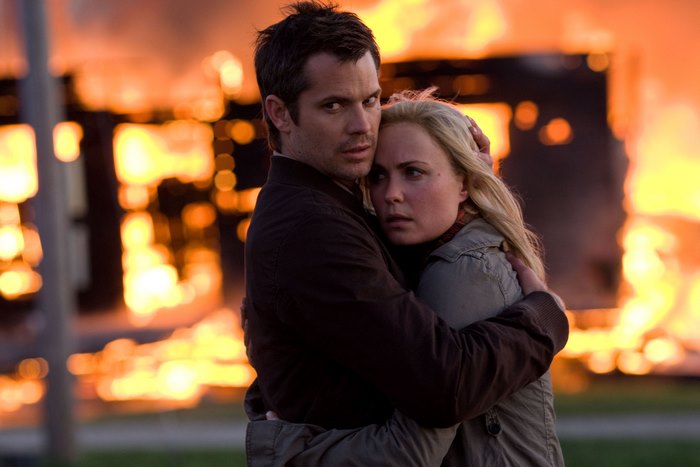 Man and woman embracing in front of a fire