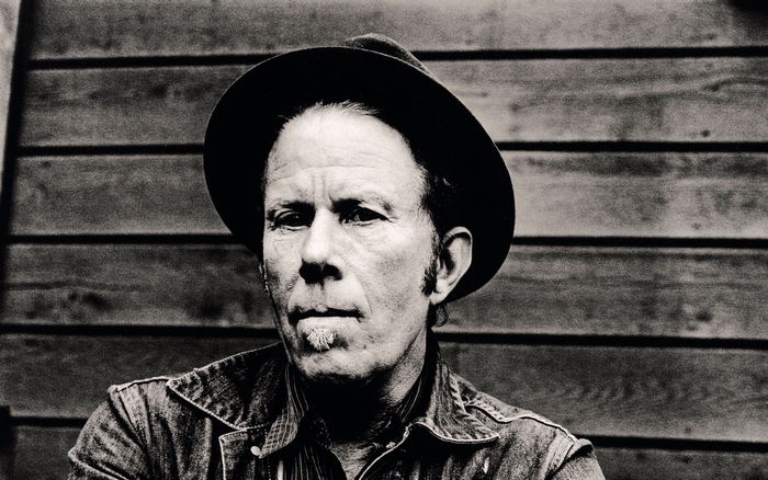 Tom Waits wearing a hat and denim jacket