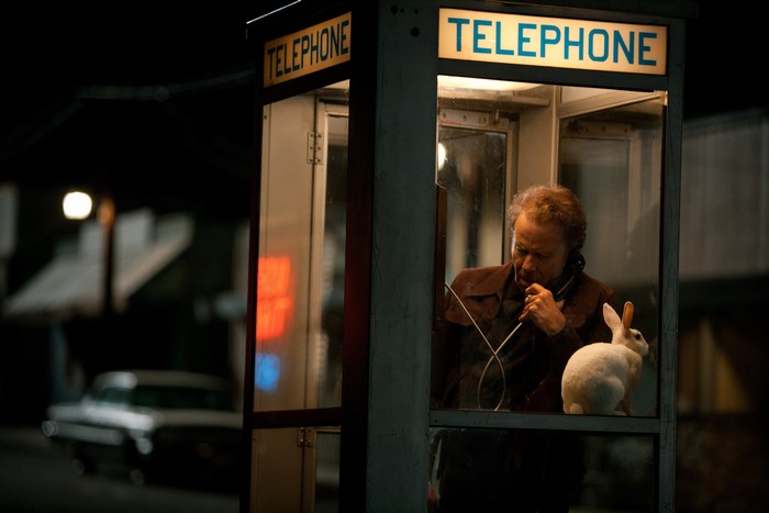 Tom Waits in a telephone booth with a rabbit