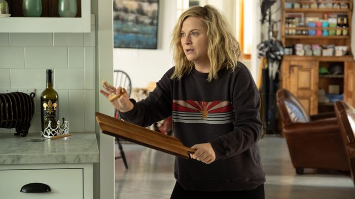 Amy Poehler holding a wooden paddle