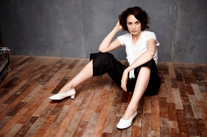 Tuppence Middleton sitting on wooden floor