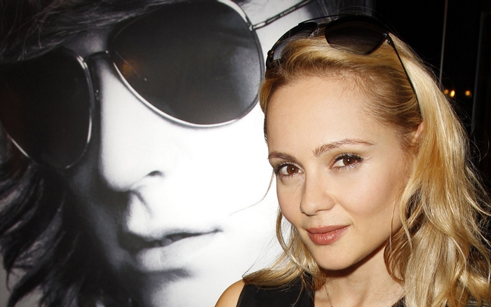 Beatrice Rosen in front of a large black and white poster