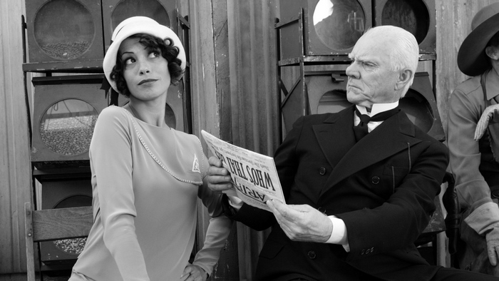 Bérénice Bejo and man reading newspaper