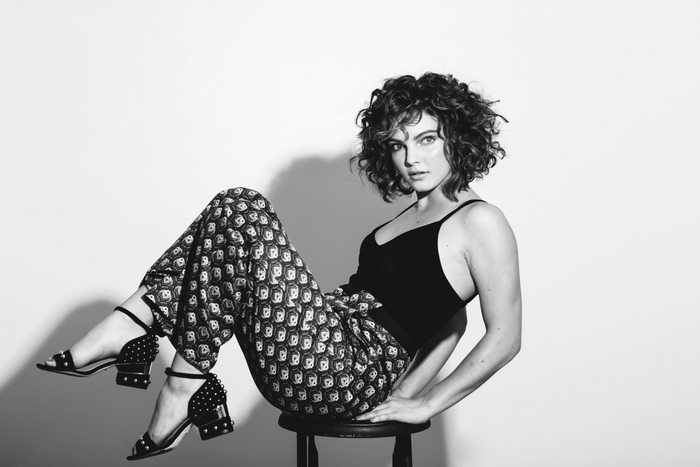 Camren Bicondova sitting on a stool