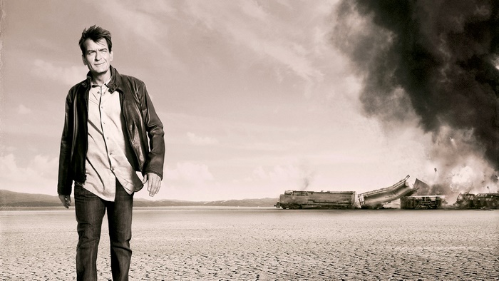Charlie Sheen in a desert with a train crash