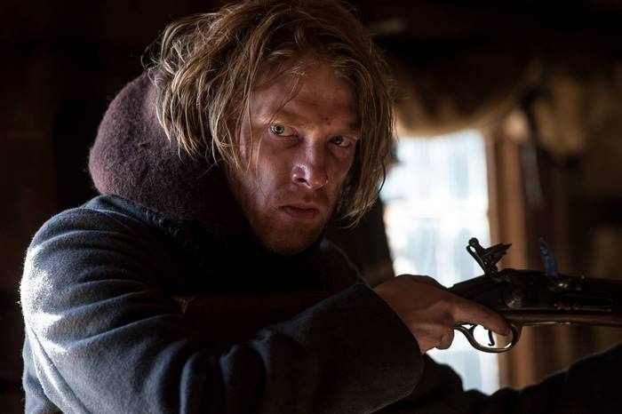 Domhnall Gleeson holding a rifle