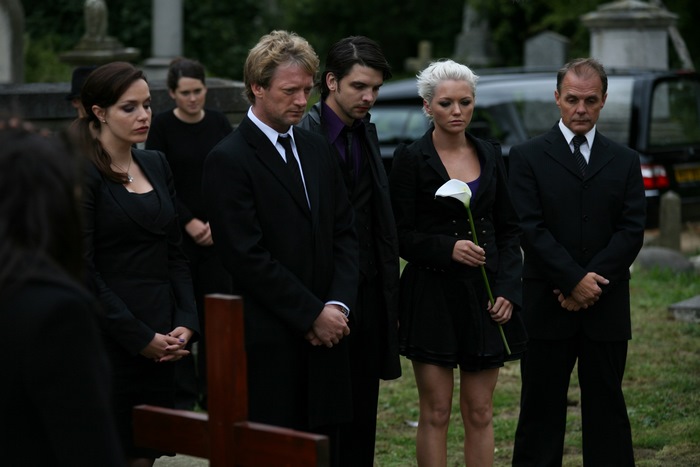 People at a funeral with a hearse