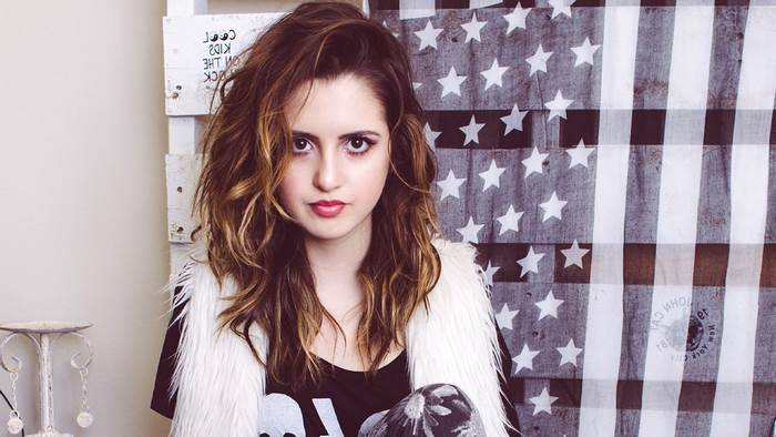 Laura Marano in front of American flag backdrop