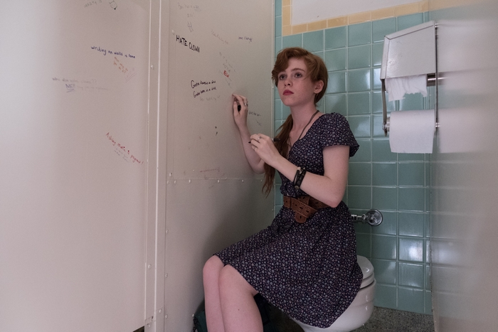 Sophia Lillis in a bathroom stall