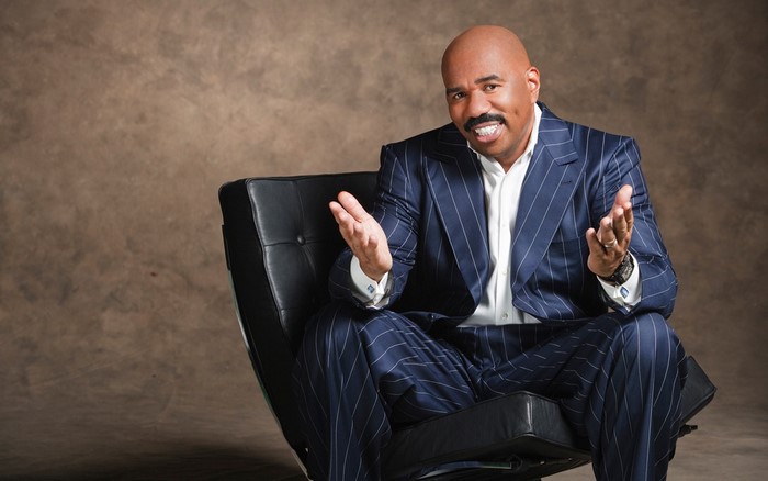 Steve Harvey sitting in a chair