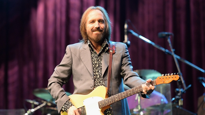 Tom Petty playing guitar on stage