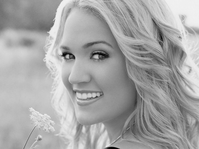 Carrie Underwood smiling with a flower