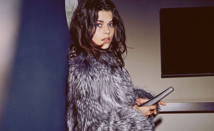Georgia Fowler in a fur coat holding a remote