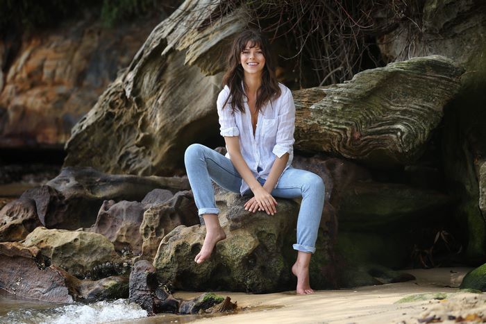 Georgia Fowler sitting on rocks at the beach