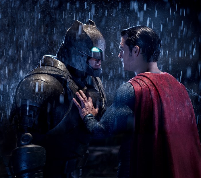 Batman in armor and Superman in rain
