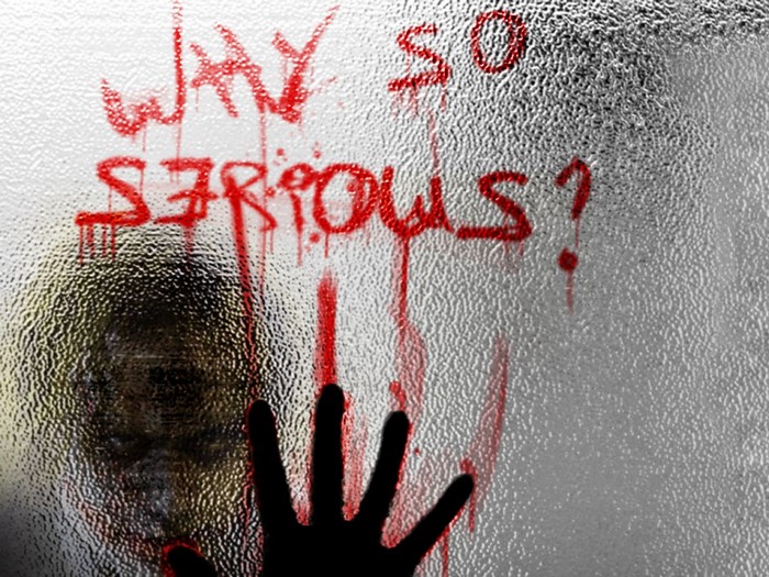 Joker writing 'Why So Serious?' on glass