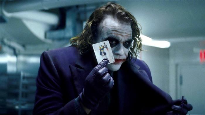 The Joker from The Dark Knight holding a playing card