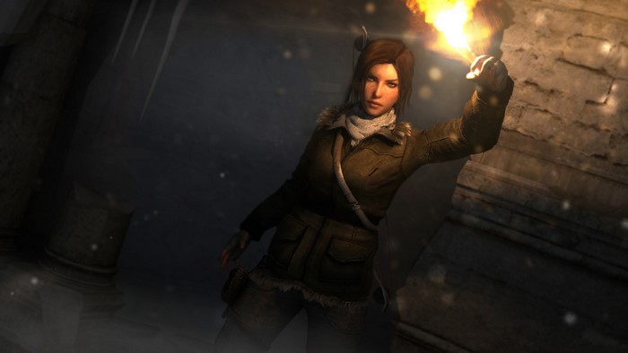 Lara Croft holding a torch in a dark cave