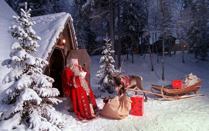 Santa Claus with reindeer and sleigh in snowy forest
