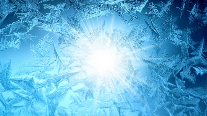 Frost patterns on a window with sunlight