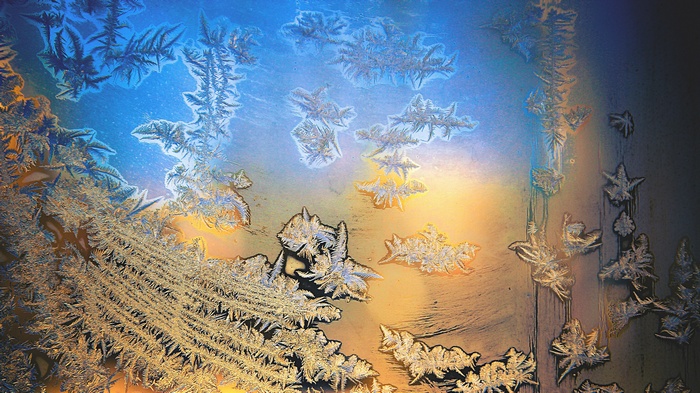 Frost patterns on a window with colorful light