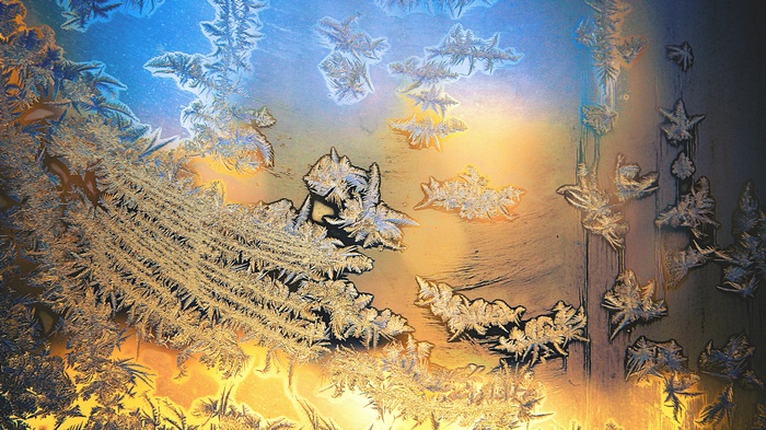 Frost patterns on a window with colorful light