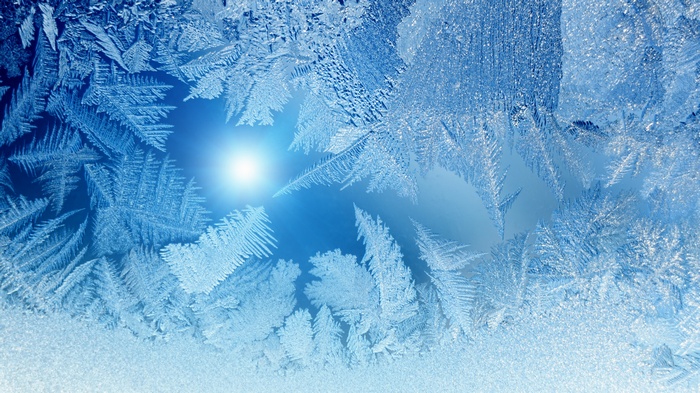 Frost patterns on a window with sunlight