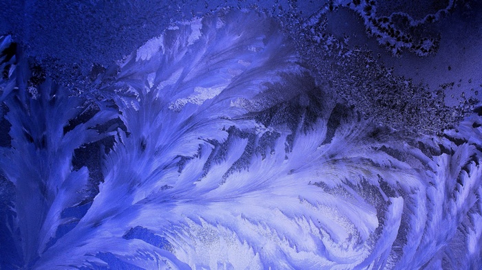 Close-up of frost patterns on a blue surface