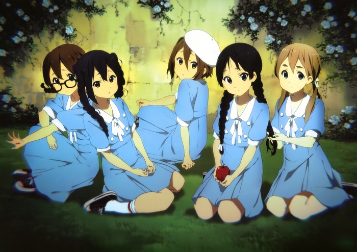 Five girls in blue dresses sitting in a garden
