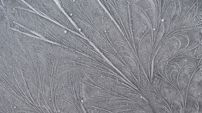 Frost patterns on a dark surface