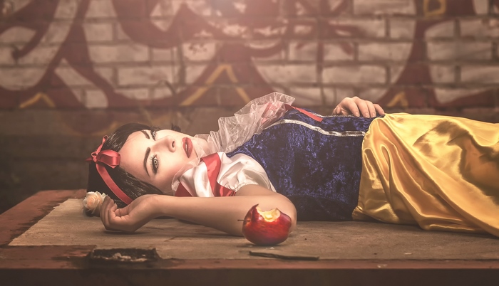 Snow White lying down with a bitten apple