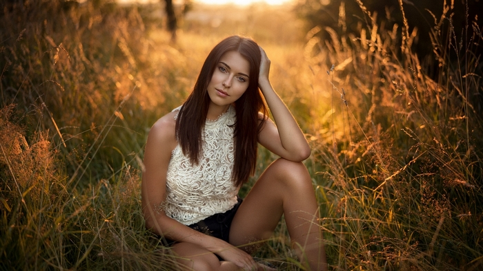 Brunette Woman Relaxing in a Sunlit Field