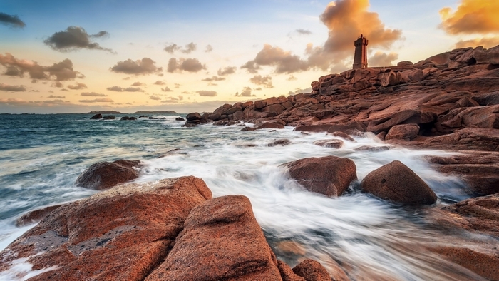 Rocky Coastline with Lighthouse at Sunset