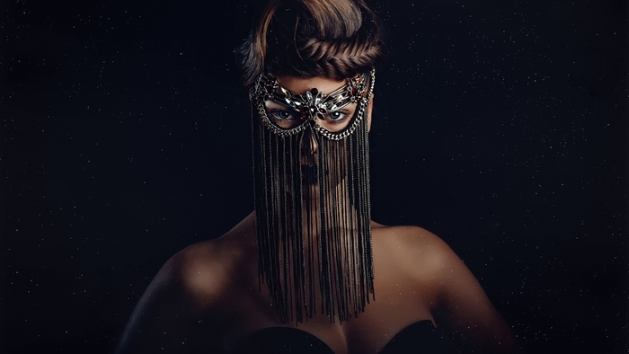 Woman in ornate mask with chains and stars