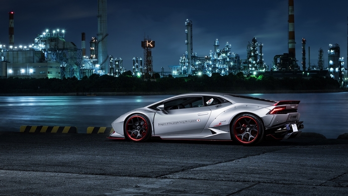 Silver Lamborghini Huracan with red accents at industrial complex