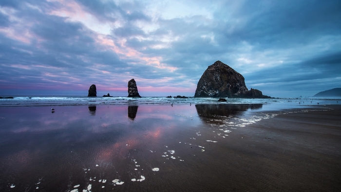 Haystack Rock and sea stacks at Cannon Beach, Oregon at sunset