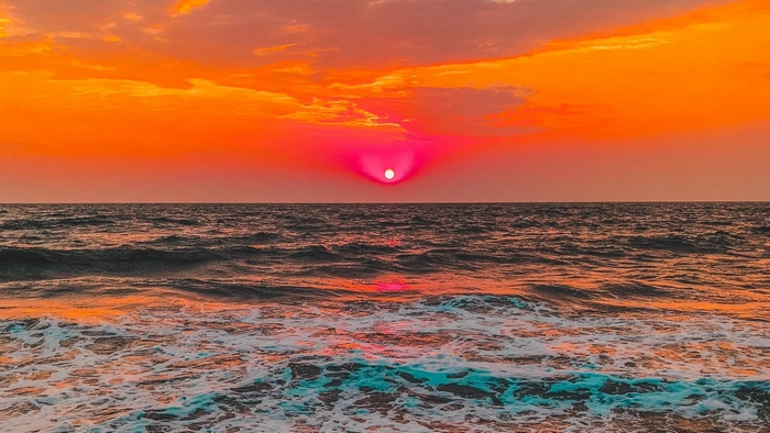 Sunset over the ocean with waves