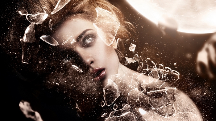 Woman's face shattering into glass fragments