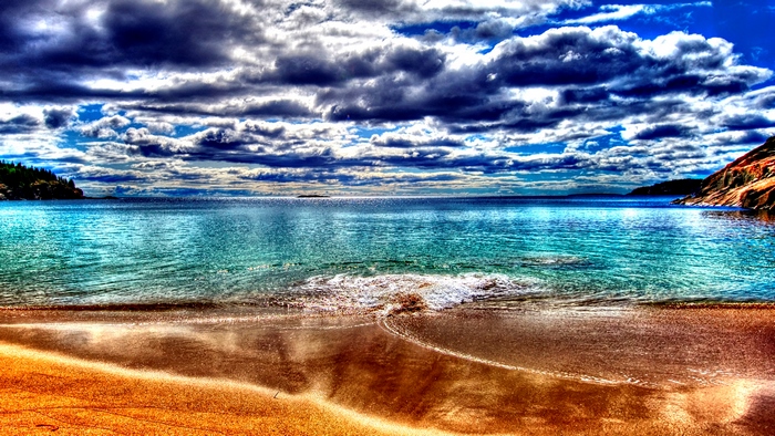 Beach with ocean waves and dramatic clouds