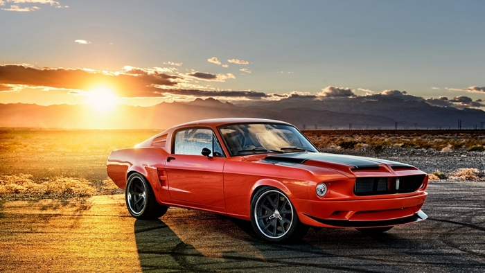 Orange Ford Mustang muscle car at sunset