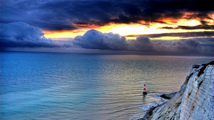 Lighthouse on the coast during sunset with dramatic clouds