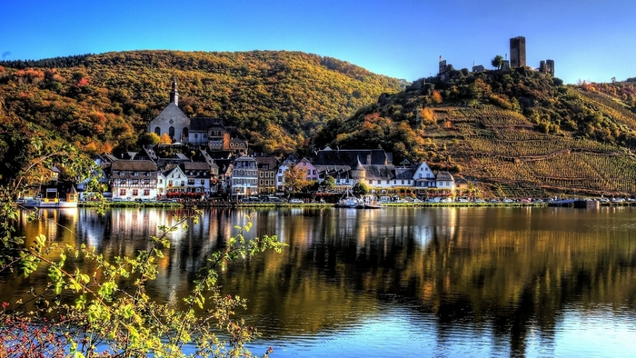River town with castle on hill in autumn