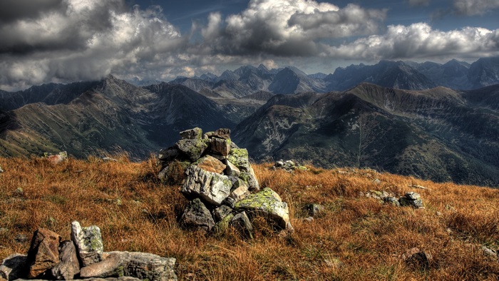 Mountain panorama with dramatic clouds and rocky foreground