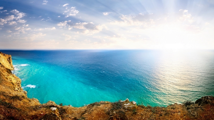 Sunlight over the ocean from a cliff