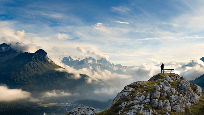 Solitary Man Standing on Rocky Hill with Mountain View