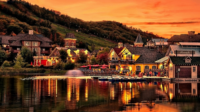 Village by a lake at sunset with reflection