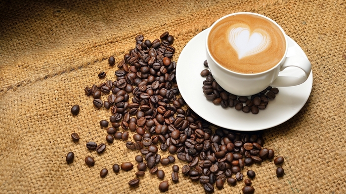 Latte with heart art and coffee beans
